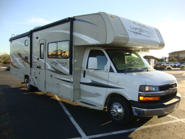 The Coachmen 320BH Class C Bunkhouse is seen driving down the road, showcasing its sleek design and spacious accommodations