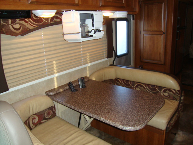 The Coachmen 320BH Class C Bunkhouse is equipped with a dining setup, offering a comfortable space for enjoying meals while on the road