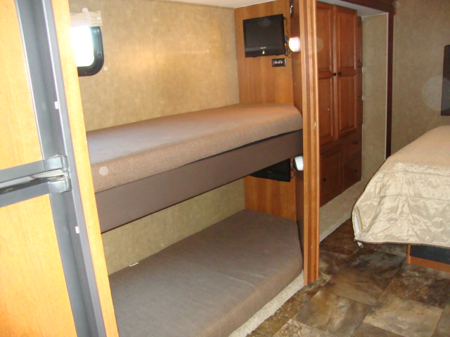 The Coachmen 320BH Class C Bunkhouse includes two small beds positioned one after the other, providing sleeping accommodations for multiple passengers