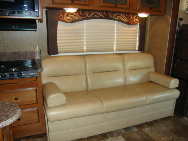 The Coachmen 320BH Class C Bunkhouse is equipped with a comfortable sofa set, providing a cozy seating area for relaxing or entertaining