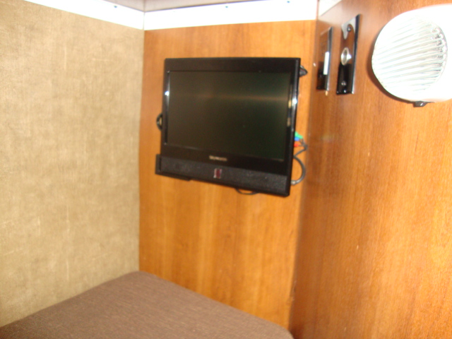 The Coachmen 320BH Class C Bunkhouse features a TV mounted on a wooden wall, adding to the comfort and convenience of the living space
